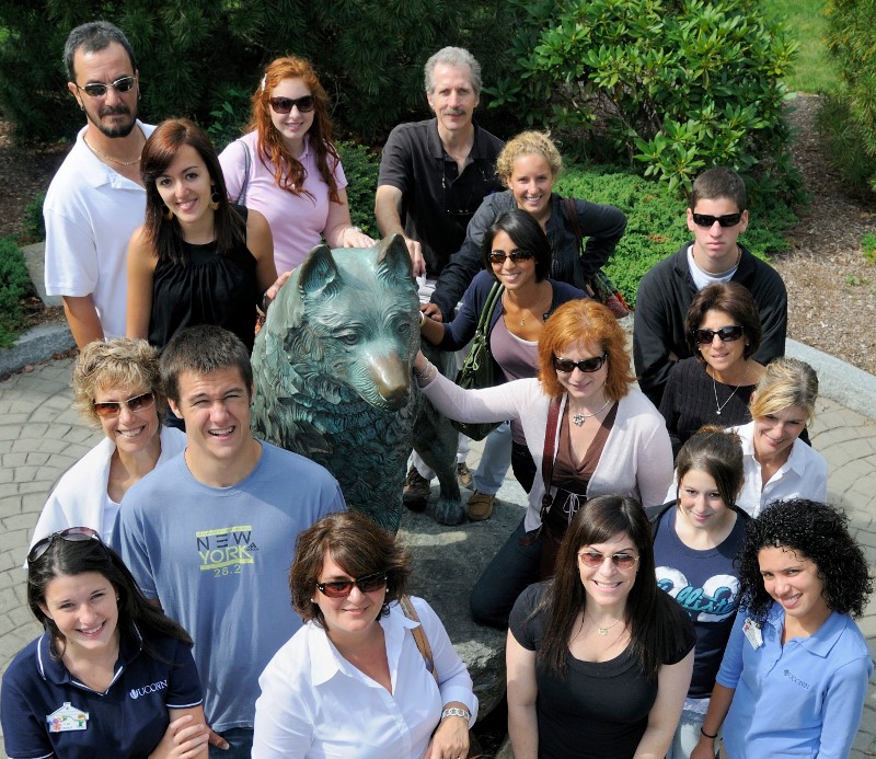 group photo in front of metal statue of jonathon the husky dog